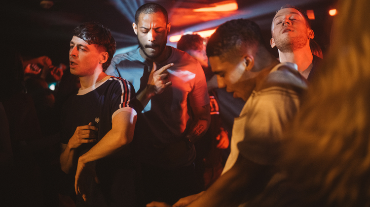 Four men dancing in a nightclub.