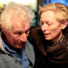 A photo of Tilda Swinton with her arm around John Berger.