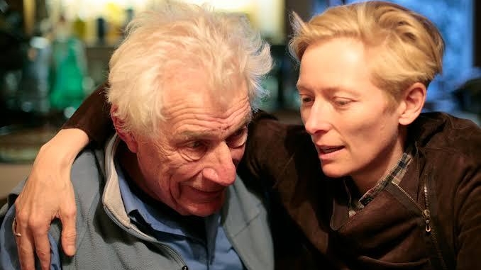 A photo of Tilda Swinton with her arm around John Berger.