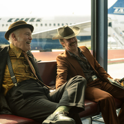 Two men in hats sitting next to each other.