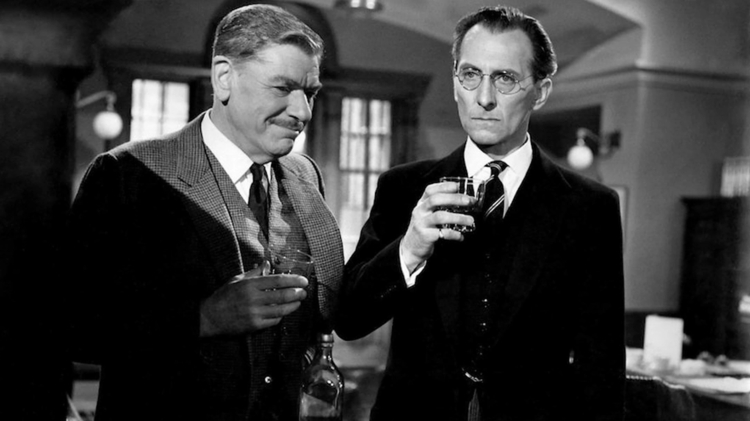 A black and white photo of two men in suits holding drinks.