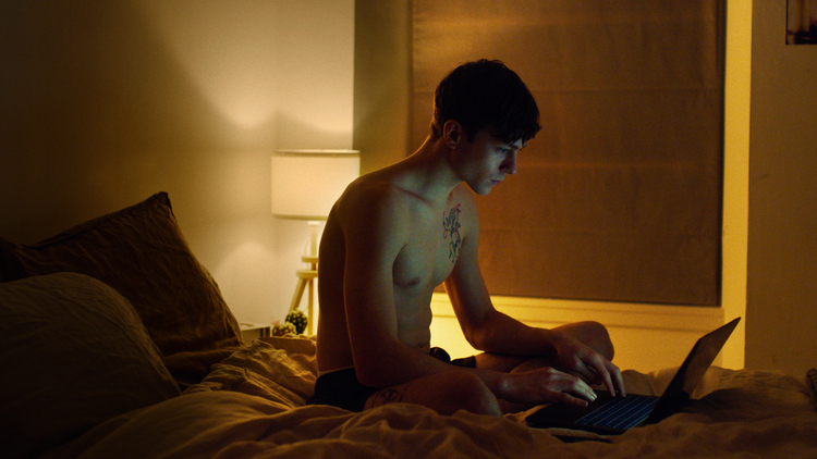 A still of a young man on his laptop from the film Sebastian