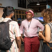 A group of people standing around chatting in the Pervasive Media Studio.