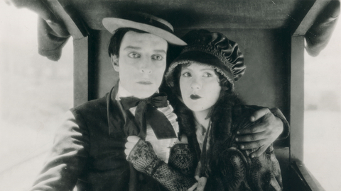 A man and woman cling to each other tightly, looking into the distance.