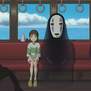 A scene from an animated film depicting a train interior with a girl seated, surrounded by shadowy figures and ocean views outside.