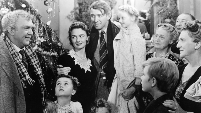 A black-and-white family gathering around a decorated Christmas tree, celebrating joyfully amidst holiday decorations and gifts.