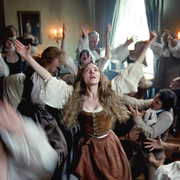 A chaotic gathering of people in historical attire dancing exuberantly, with arms raised and expressions of joy and excitement.