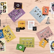 An image showing a tutorial for Max Haiven's board game, Billionaires and Guillotines. Various digitally rendered squares lie on the wooden table, showing a multitude of concepts, from power, legacy, toys, vanity and influence. Various flow charts connect the concepts to other squares of text, detailing the rules of the board game. 