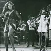 A dynamic stage scene featuring performers in vibrant costumes during the historic Soul to Soul concert in Ghana.