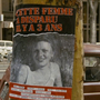 A missing person poster on a tree trunk, featuring a blurred image and text in French about a woman who disappeared three years ago.