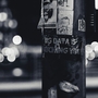 A black and white image of a lamp post with text written on it - the text reads "Big Data is Watching You", and is written on the lamp post with white ink on the black structure. 