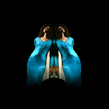 An image of the voice artist Angelica Allen. She is posing in the centre of the image, and is mirrored, creating a rorschach-test like image of two Angelicas side by side, seemingly leaning on each other. 