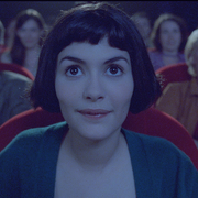A still from Amélie of the lead character sitting in the cinema