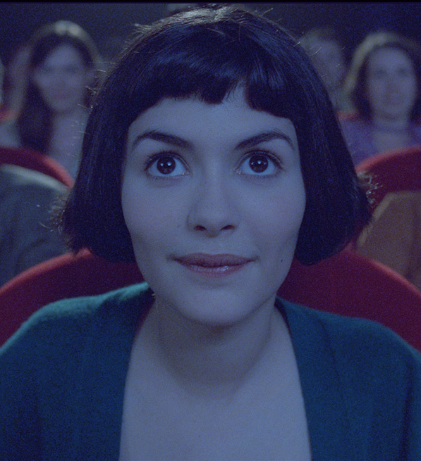 A still from Amélie of the lead character sitting in the cinema