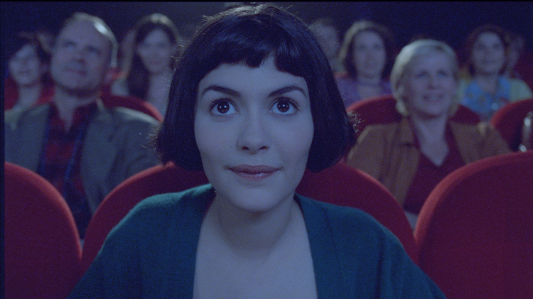 A still from Amélie of the lead character sitting in the cinema