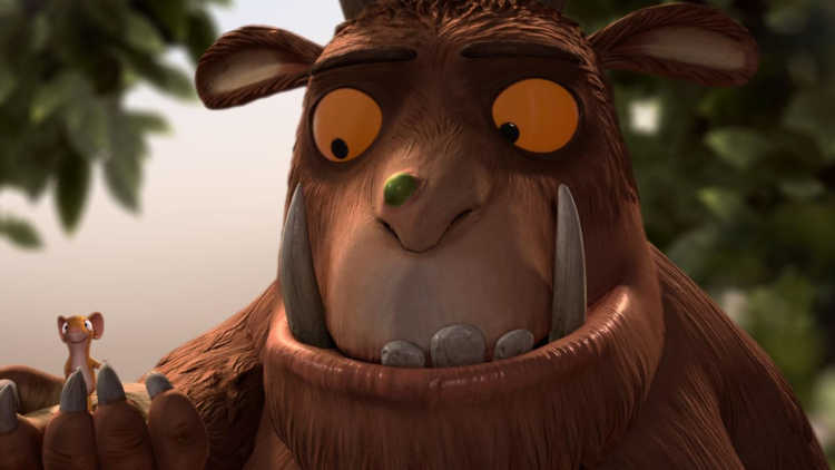 Animated large furry creature with big tusks holds a small smiling mouse on its hand in a forest setting.