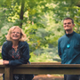 A still from the film I Swear of a man and a woman leaning on a fence.