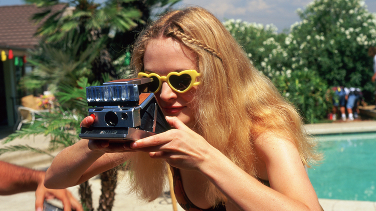 Boogie Nights - a woman taking a picture with a polaroid camera