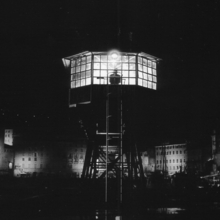 A night view of a signalman's tower with a silhouette of a person in the tower.