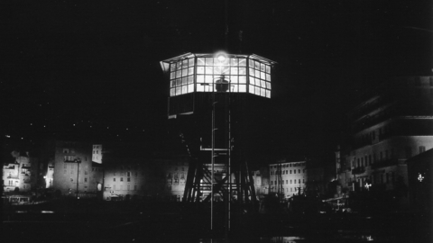 A night view of a signalman's tower with a silhouette of a person in the tower.