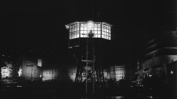 A night view of a signalman's tower with a silhouette of a person in the tower.
