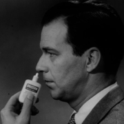 A still from The Movie Orgy - black and white photo of a man in a suit applying Dristan nasal spray to his nose.