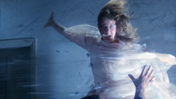 A still from Boorman and the Devil of a woman wrapped in a white sheet in a dramatic pose with her hair blowing in the wind.