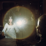 A still from Exorcist II: The Heretic of a girl sitting in a chair with a device on her head with wires coming out of it.