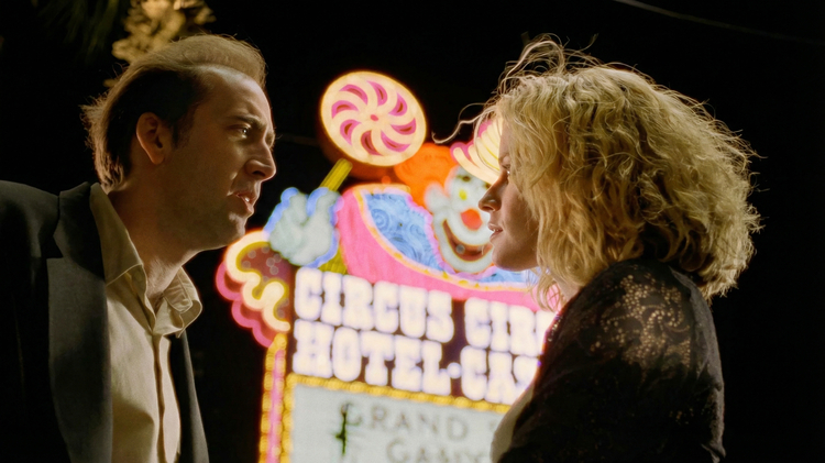 Two people look at each other in front of a neon sign for Circus Circus Hotel Casino