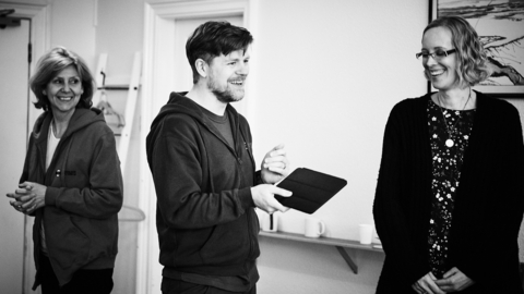 A black and white photo of three people standing in a room.