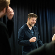 A still of a person teaching an improv class.