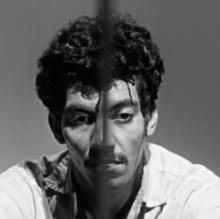 A black and white photo of a man looking down.