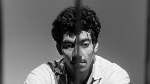 A black and white photo of a man looking down.