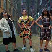 Three people standing outside looking at the camera with their hands on their hips.