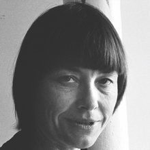 A black and white close up of a person holding a camera.