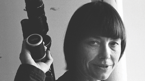 A black and white close up of a person holding a camera.