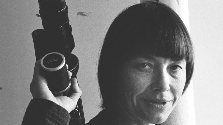 A black and white close up of a person holding a camera.