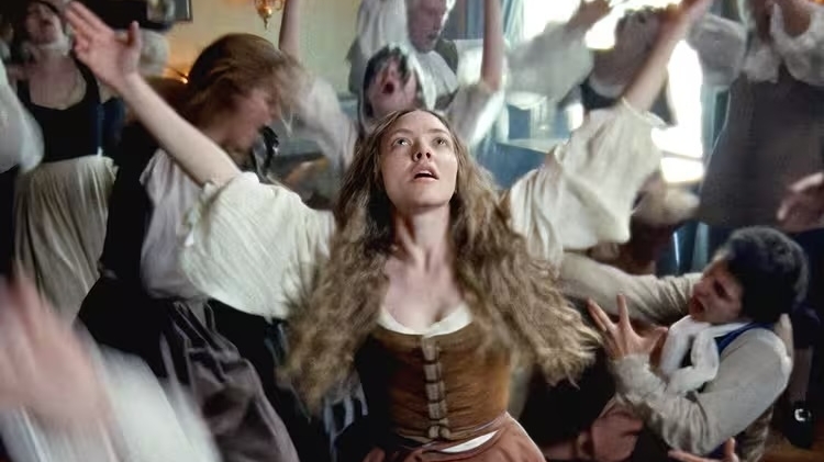 A chaotic gathering of people in historical attire dancing exuberantly, with arms raised and expressions of joy and excitement.