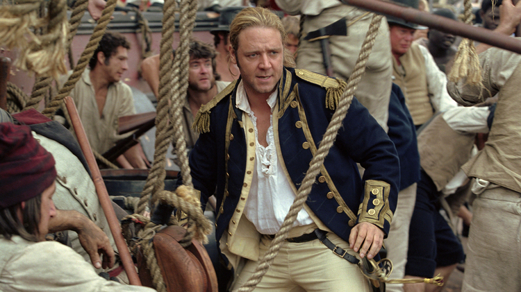 A still from Master and Commander: The Far Side of the World of a man standing on a boat surrounded by people