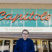 Person standing in front of the Capitole building with a "cinémathèque suisse" sign above the entrance.