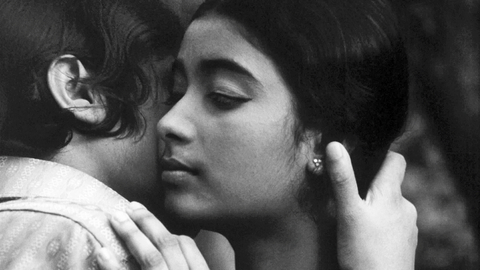 A black and white photo of two young people in an embrace.