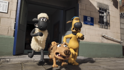 Claymation characters Shaun the Sheep, Bitzer the dog, and Toby the terrier stepping out of the "Animal Containment Unit" building.