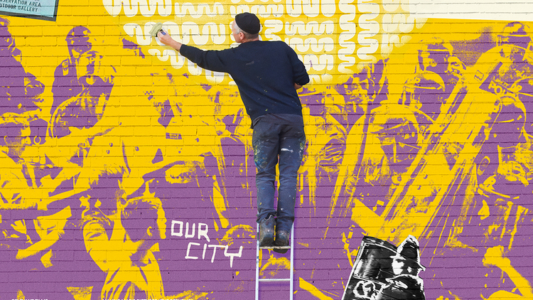 A man on a ladder painting