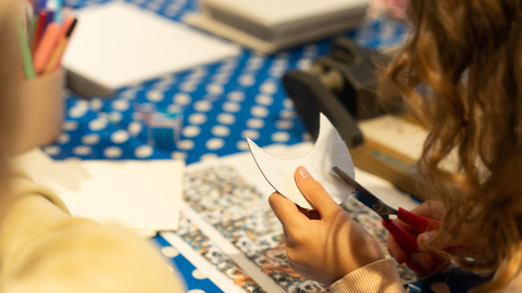 An image of a child cutting some paper