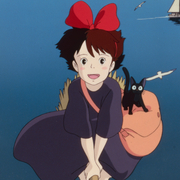 Animated girl with a large red bow, black cat, and bag riding a broomstick across a blue sea with seagulls and a sailboat.