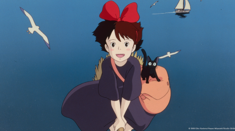 Animated girl with a large red bow, black cat, and bag riding a broomstick across a blue sea with seagulls and a sailboat.