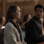 A woman stares pensively straight ahead whilst a man in a suit anticipates to hear an answer from her.