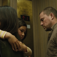 A woman is holding a child in her arms with a man standing next to them 