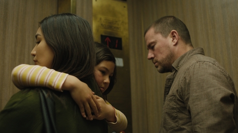 A woman is holding a child in her arms with a man standing next to them 
