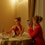 A still of three people sitting at a dinner table all on their phones.